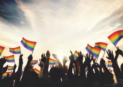 Hands raised with rainbow flags